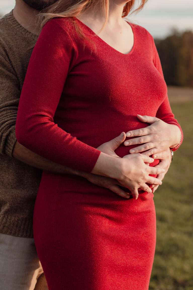Photo d'une ventre de femme enceinte avec les mains de son compagnon sur son ventre